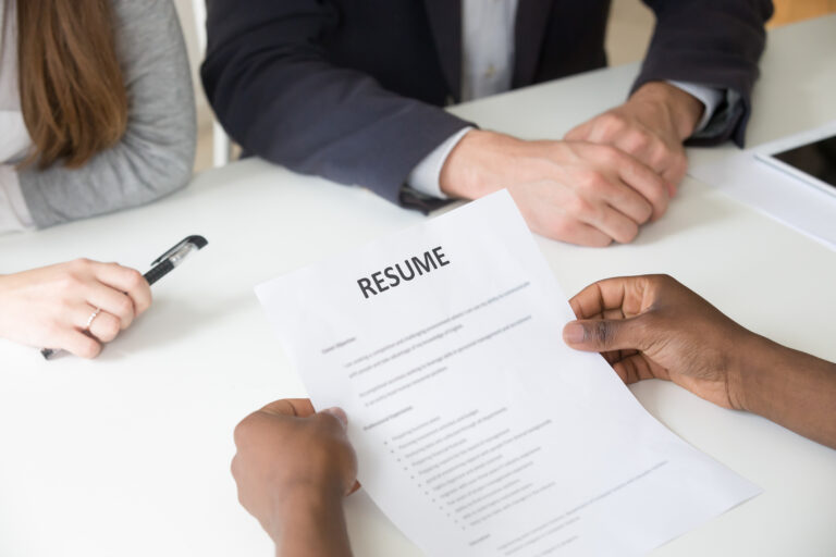 african american applicant holding resume job interview close up view - Recruiterfy.ai